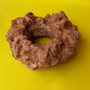 A crispy donut made from small dough pieces joined together, coated in autumn spice sugar.