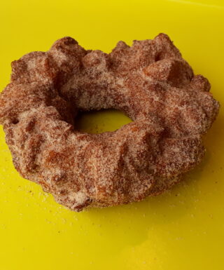 A crispy donut made from small dough pieces joined together, coated in autumn spice sugar.