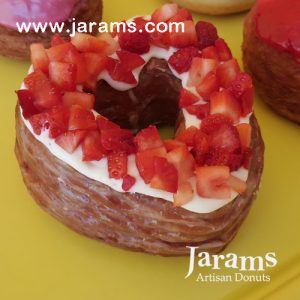 A beautifully crafted Valentine’s Strawberry Cream Cheese Croissant Heart Donut, topped with rich cream cheese frosting and decorated with fresh diced strawberries, placed on a golden, flaky croissant base. A luxurious and refreshing treat for Valentine’s Day.