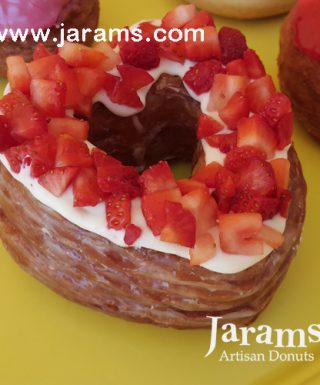 A beautifully crafted Valentine’s Strawberry Cream Cheese Croissant Heart Donut, topped with rich cream cheese frosting and decorated with fresh diced strawberries, placed on a golden, flaky croissant base. A luxurious and refreshing treat for Valentine’s Day.