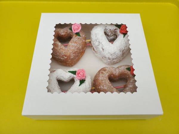 A beautifully crafted Valentine’s Powdered Sugar Croissant Cupid Donut, dusted with fine powdered sugar, topped with a delicate candy rose, and pierced with a strawberry cream Pocky stick as Cupid’s arrow. A crispy, flaky croissant donut perfect for Valentine’s Day.