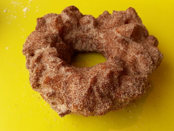 A crispy donut made from small dough pieces joined together, coated in autumn spice sugar.