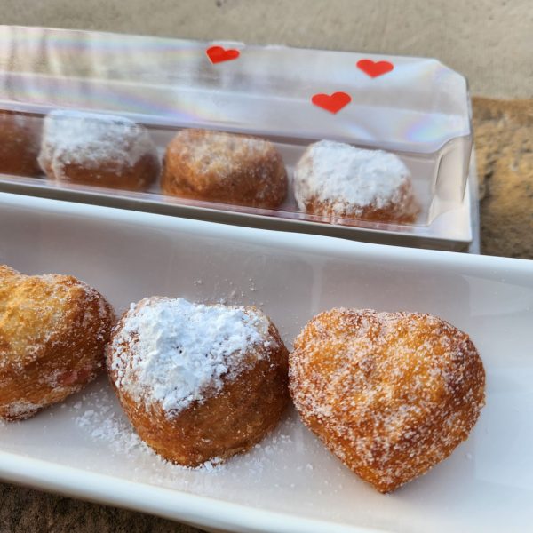 A beautifully packaged Mini Croissant Heart Donut Gift Set with five heart-shaped croissant donuts, filled with strawberry jam and custard cream, lightly dusted with regular or powdered sugar, arranged in a clear plastic mini gift box—a perfect treat for Valentine’s Day and special occasions.