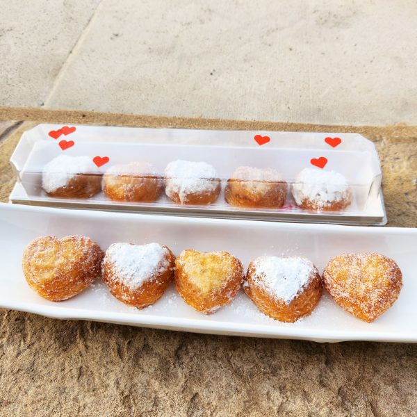 A beautifully packaged Mini Croissant Heart Donut Gift Set with five heart-shaped croissant donuts, filled with strawberry jam and custard cream, lightly dusted with regular or powdered sugar, arranged in a clear plastic mini gift box—a perfect treat for Valentine’s Day and special occasions.